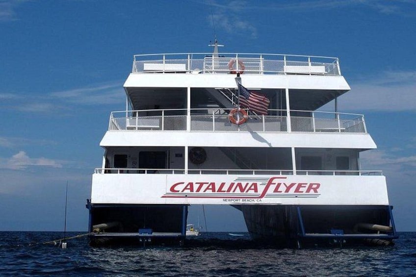 A white ferry named Catalina Flyer with an American flag, docked at Newport Beach. 5