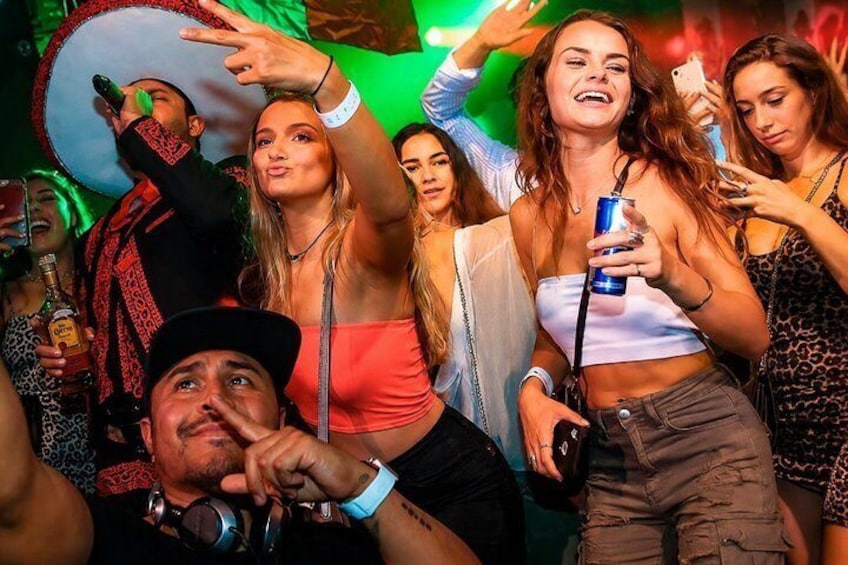 En grupp människor på en fest med en DJ-bås och en discokula. 3