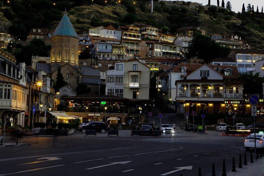 A street with buildings, a church, and cars. 3