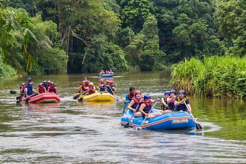 People rafting on a river surrounded by lush greenery. 1
