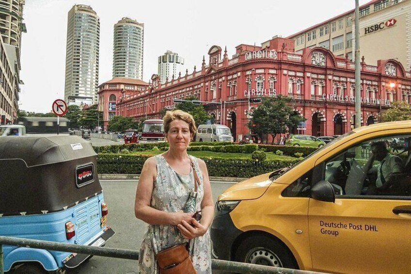 Eine Frau steht neben einem gelben Taxi in einer Stadt mit hohen Gebäuden, darunter ein Gebäude mit 'HSBC'. 4