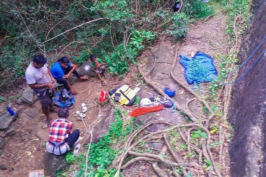 A group of people in a forested area with a makeshift campsite. 5