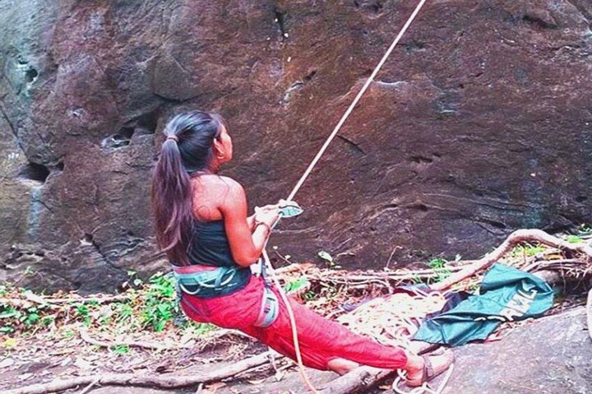 A person rappelling down a rocky cliff. 4