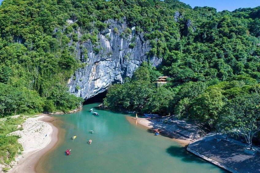 Un fiume con barche, una spiaggia e una scogliera ricoperta di alberi. 2