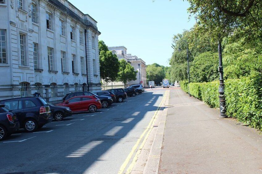 A street lined with parked cars and a building on the left. 1