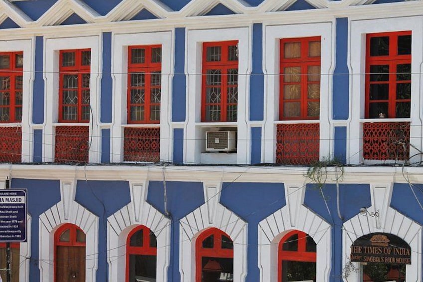 Ein Gebäude mit blauen und weißen Wänden, roten Türen und einem Schild für The Times of India. 3