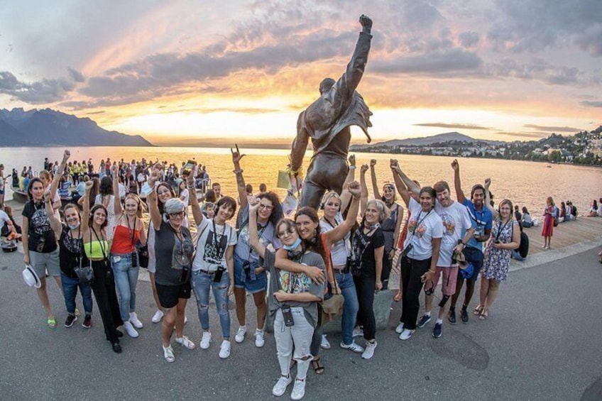 Een groep mensen die poseert met een standbeeld in een pittoreske omgeving. 2