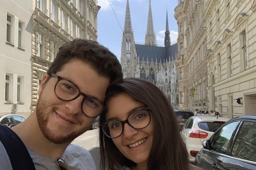 A couple in front of a historic building with spires. 1