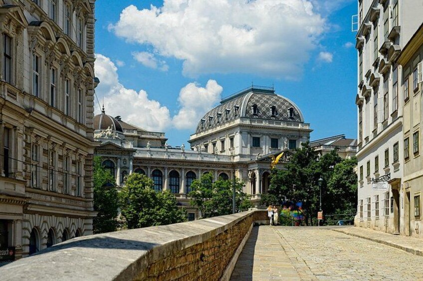 A historic building with a dome, a stone wall, and a clear blue sky. 5