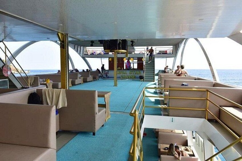 Ein Fährdeck mit Sitzbereichen, einer Treppe und einem Geländer. 3