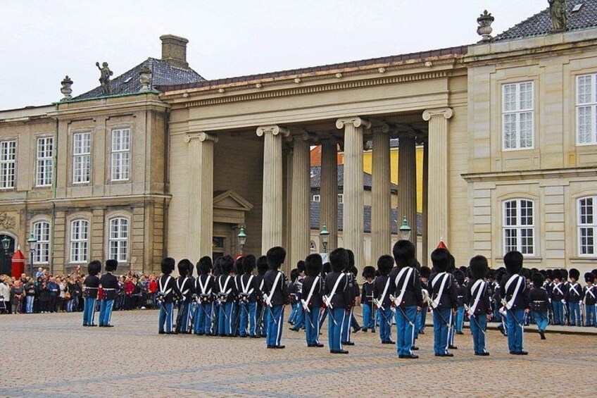 Un grupo de guardias uniformados alineados frente a un edificio histórico. 2