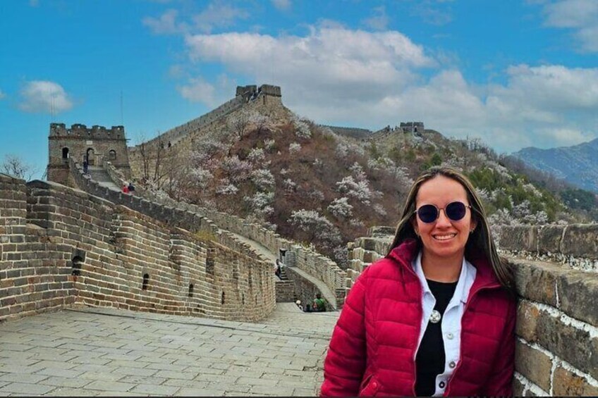 A person standing on the Great Wall of China with a mountainous backdrop. 4
