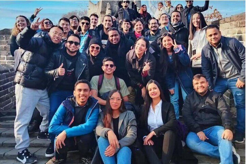 A group of people posing in front of a stone wall. 2