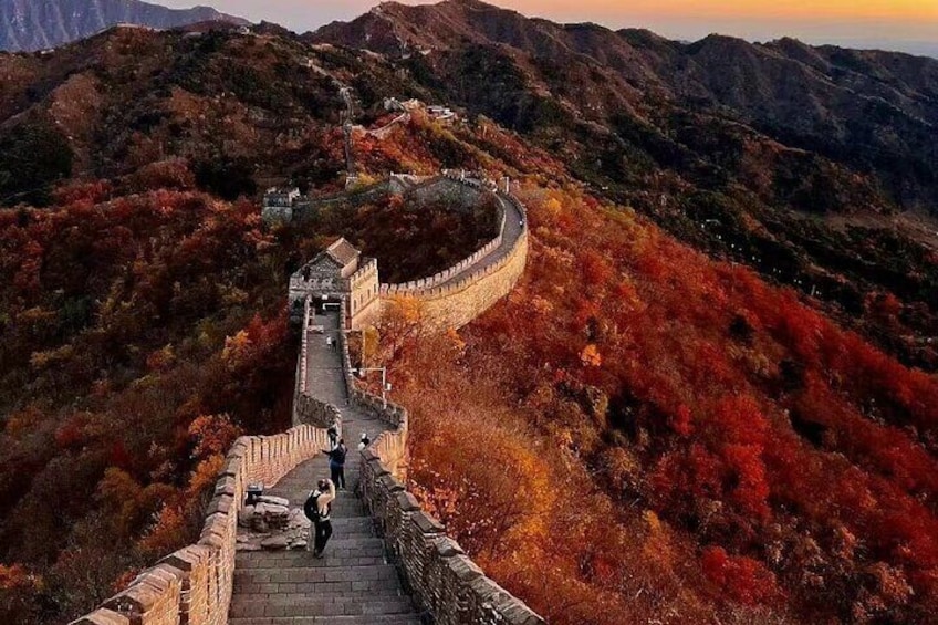 The Great Wall of China winding through a mountainous landscape with autumn foliage. 5