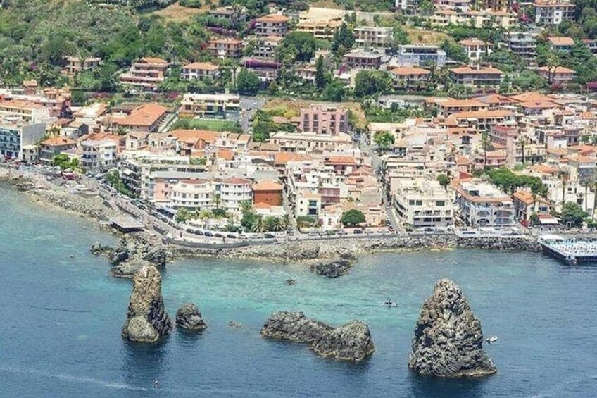 Une ville côtière avec des bâtiments, des affleurements rocheux et une eau d’un bleu limpide. 5
