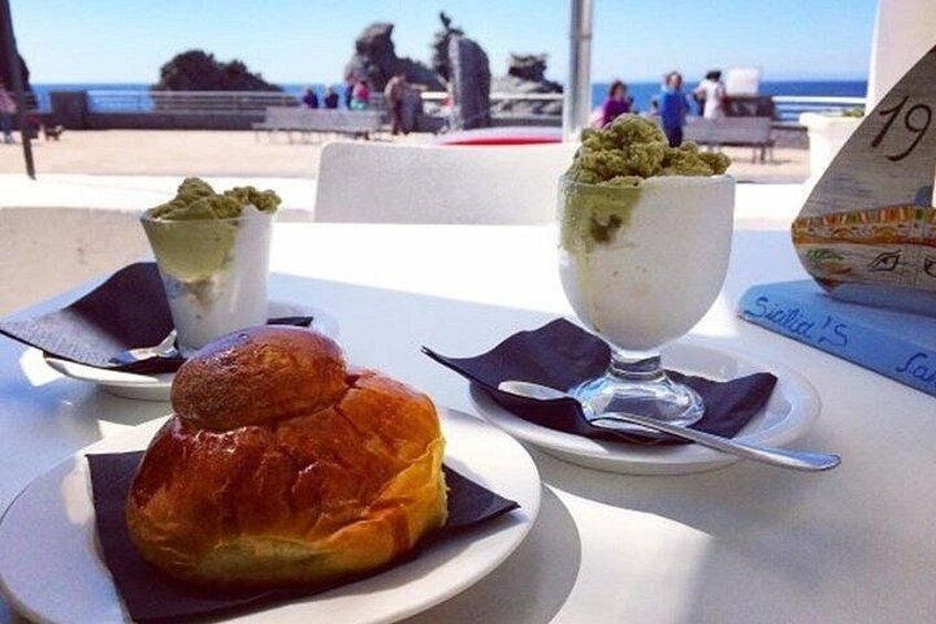 Une table avec une pâtisserie, un dessert et un menu dans un restaurant en bord de mer. 2