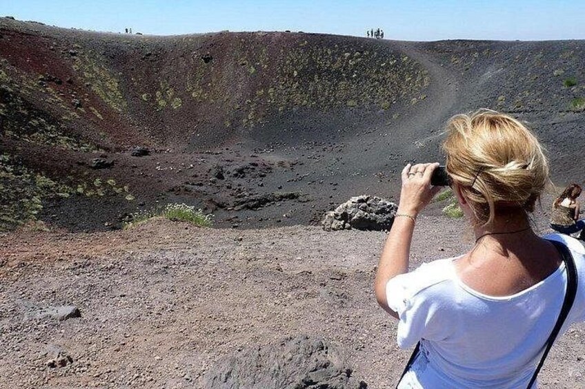 Un cratère volcanique dans lequel on aperçoit une personne prenant une photo. 5