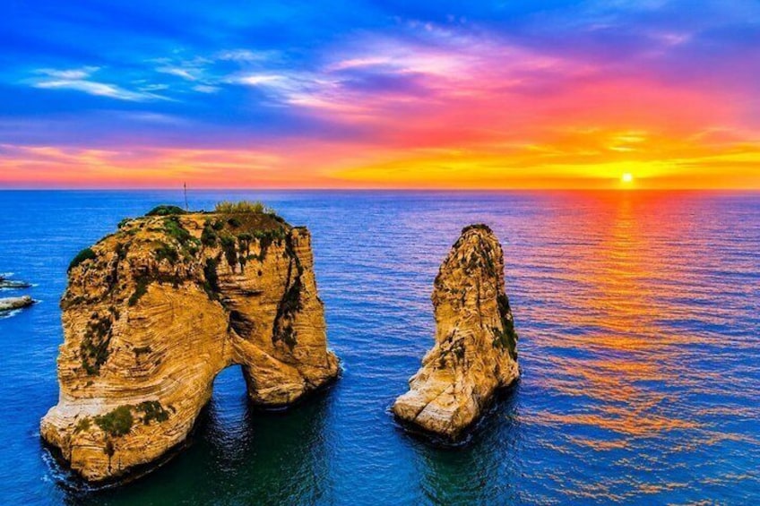A coastal rock formation at sunset with clear skies. 1