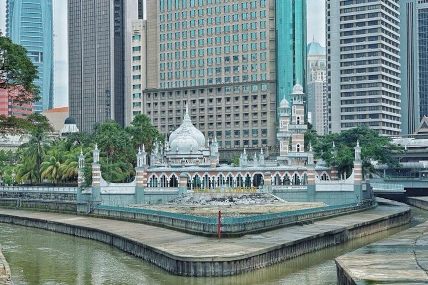 A mosque with a large dome, surrounded by a walled compound with a water feature. 5