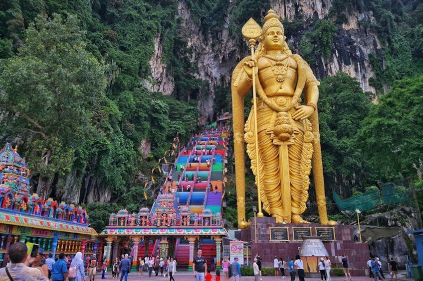 A large golden statue, a colorful temple, and a mountainous backdrop. 5