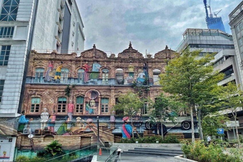 Un bâtiment historique orné de peintures murales colorées, entouré d’une architecture moderne et de verdure. 5