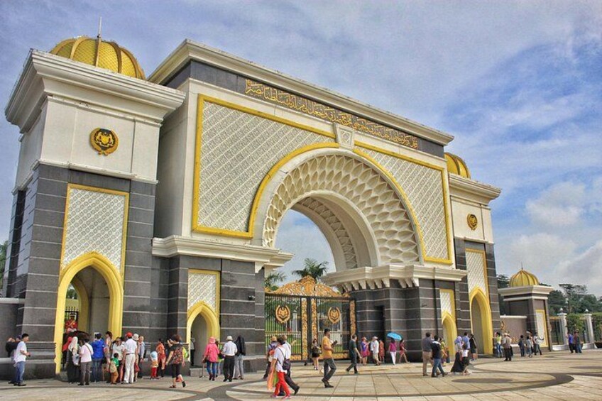A large, ornate archway with intricate designs and a crowd of people gathered in front. 4
