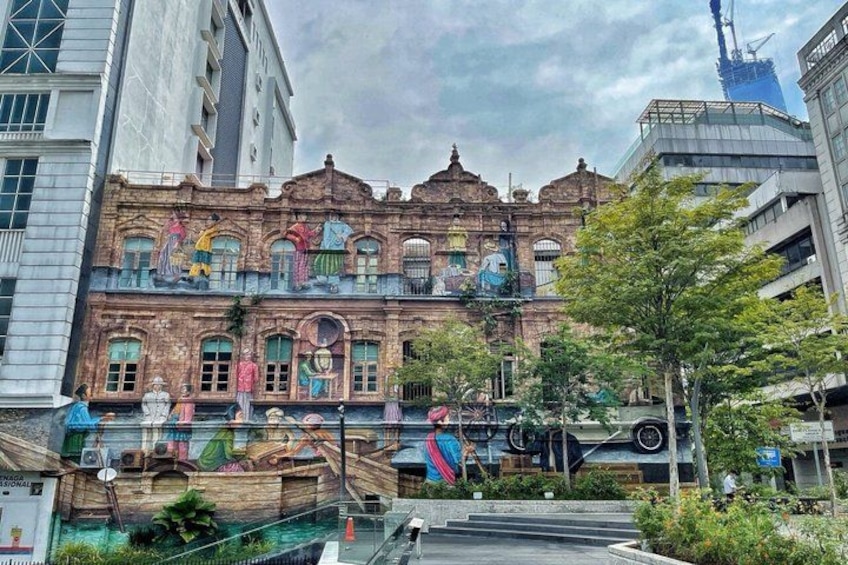A historic building with colorful murals, surrounded by modern architecture and a construction crane. 4