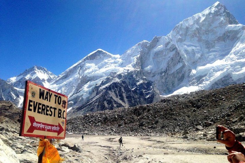 En skylt som visar vägen till baslägret vid Mount Everest, med ett bergigt landskap i bakgrunden. 1