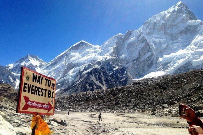 Señal que indica el camino al Campo Base del Everest, con una montaña nevada al fondo. 1