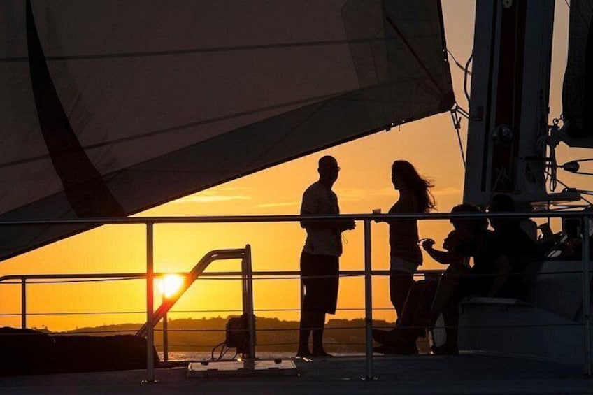 A sunset with silhouettes of people on a boat. 2