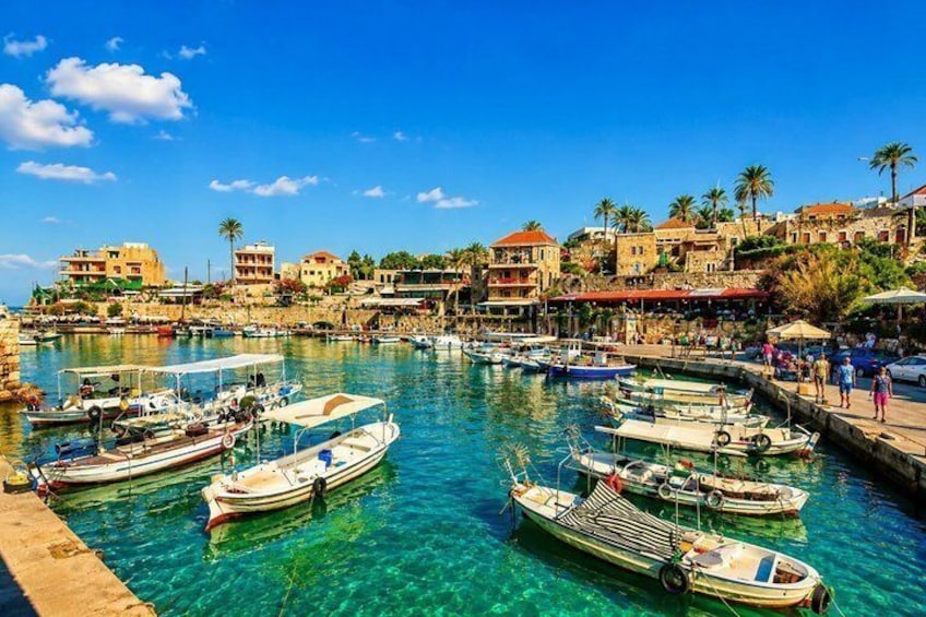Un puerto con barcos amarrados, agua cristalina y edificios a lo largo de la costa. 4