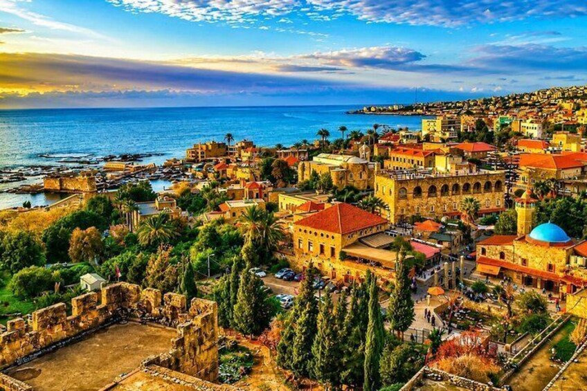 Un pueblo costero con arquitectura histórica, mar azul cristalino y una iglesia destacada con cúpula. 1