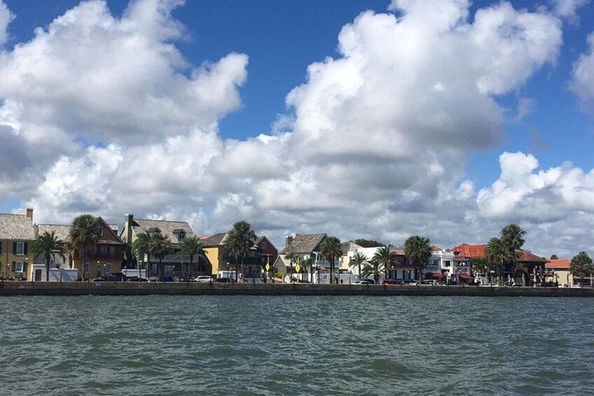 Un paisaje marítimo con edificios, palmeras y cielo despejado. 5