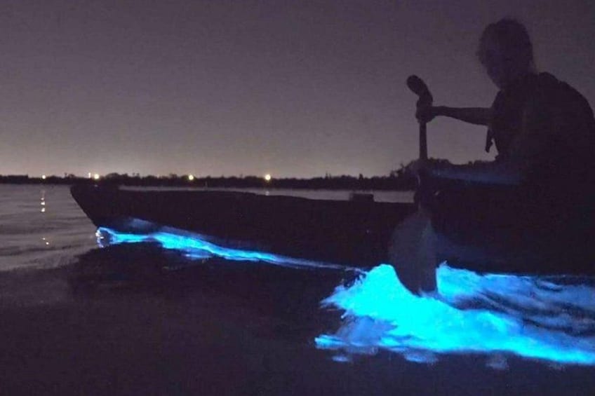 A boat with blue lights on the water at night. 1