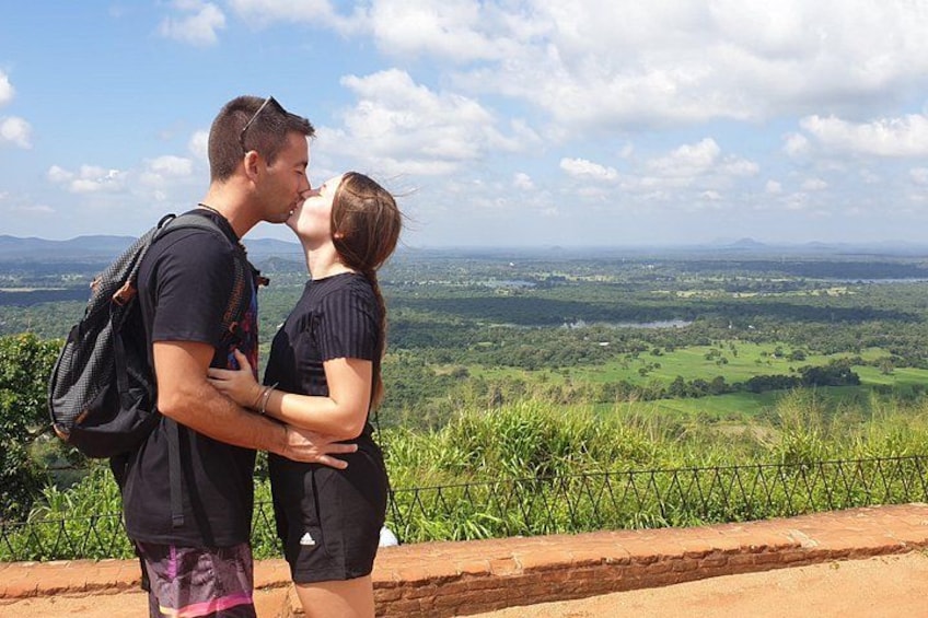 Un couple s’embrasse sur une colline, d’où l’on peut admirer un vaste paysage. 2