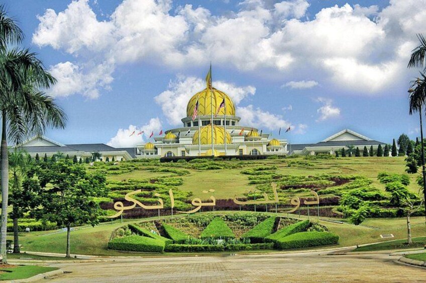 A large building with a golden dome, surrounded by well-manicured gardens and palm trees. 3