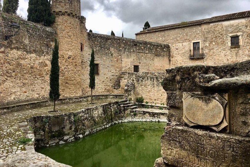 A stone building with a moat and a tower. 2