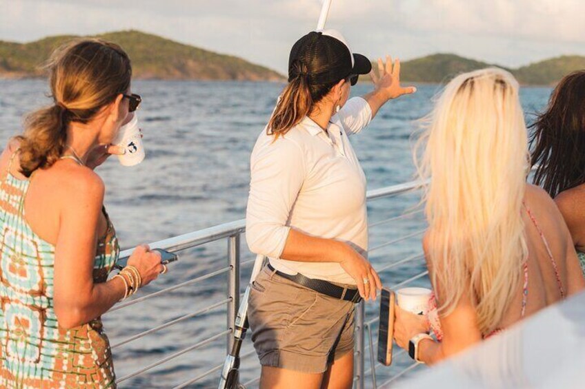 A group of people on a boat with a body of water and a distant landmass in the background. 5