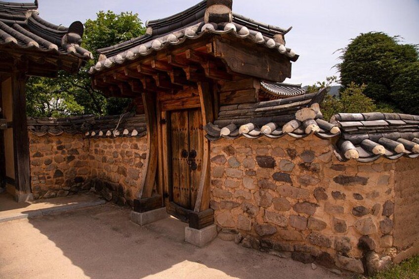A traditional Korean gate with wooden doors and tiled roof. 3