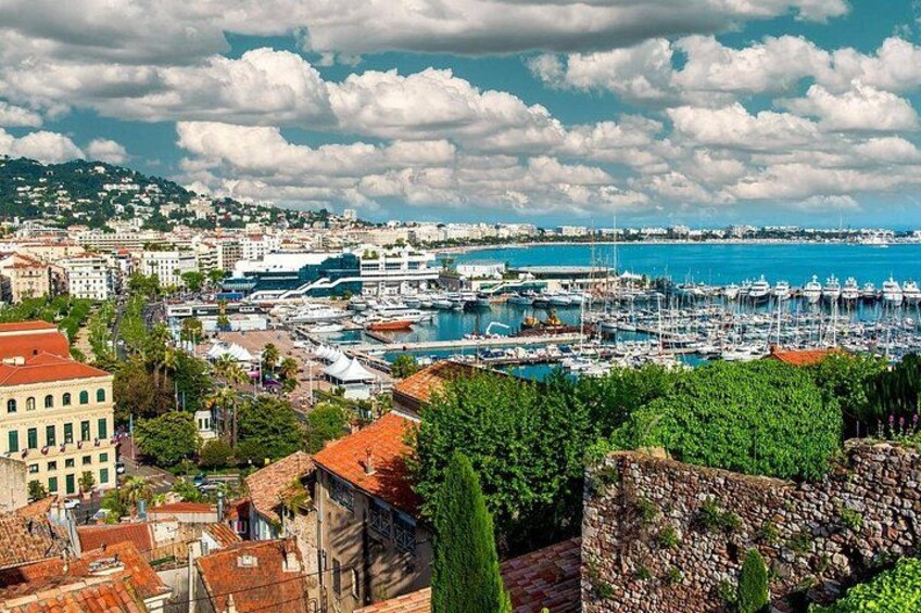 Un paysage urbain côtier avec un port de plaisance, des bâtiments historiques et un ciel dégagé. 2