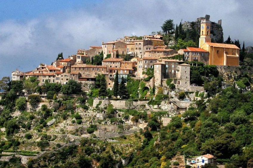 Une ville pittoresque, située sur une colline, avec des bâtiments historiques, un imposant beffroi et une végétation luxuriante. 5