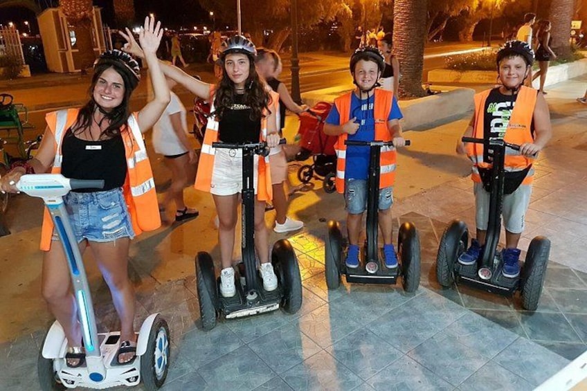 Personen rijden op segways in een open gebied, met oranje veiligheidsvesten. 5