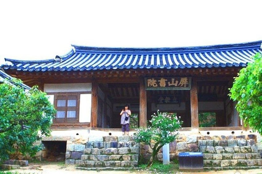 A traditional Korean building with a tiled roof and stone walls. 1