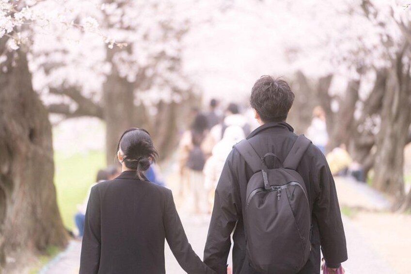 A couple walking down a tree-lined path. 2
