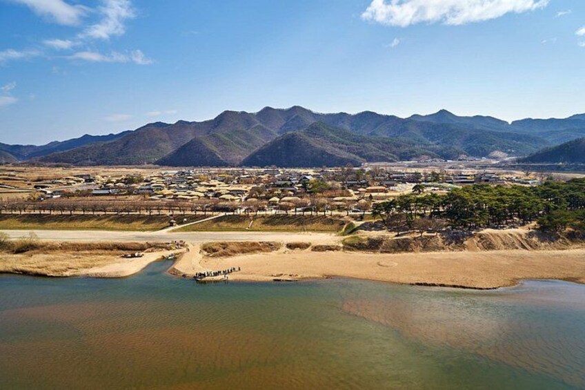 A river, a town, and mountains in the background. 5
