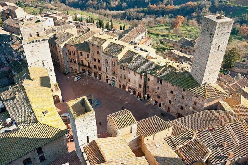 A historic town with medieval architecture, including a prominent tower and a central square. 3