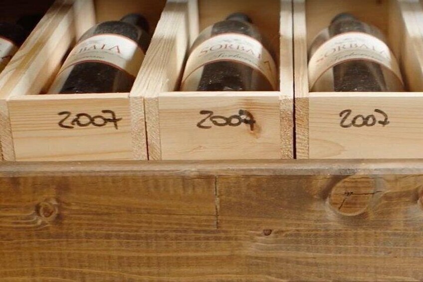 A wooden wine rack with bottles labeled 2007 and 2008. 5