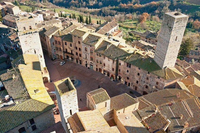 A historic town with medieval architecture, including a prominent tower and a central square. 2