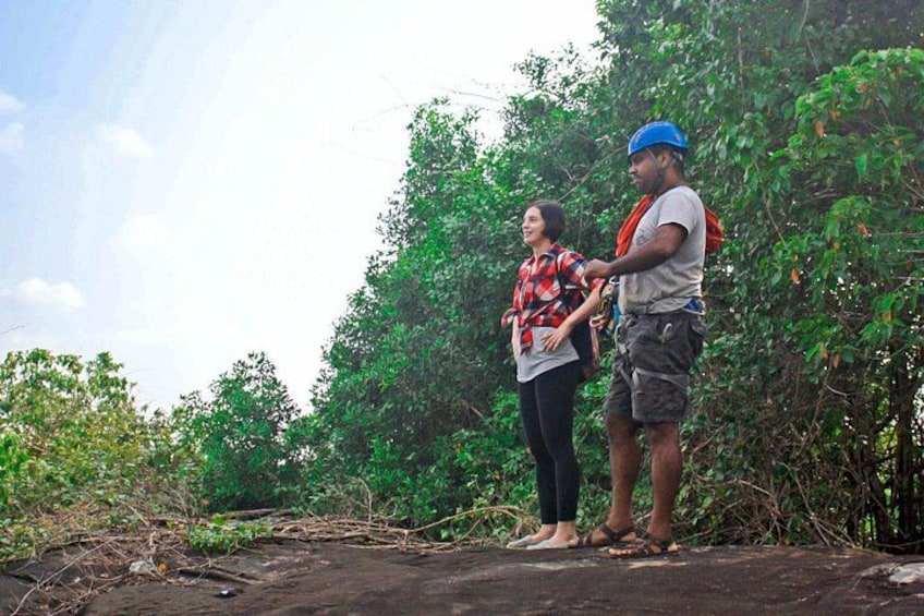 Two people standing on a dirt path surrounded by dense green foliage. 3