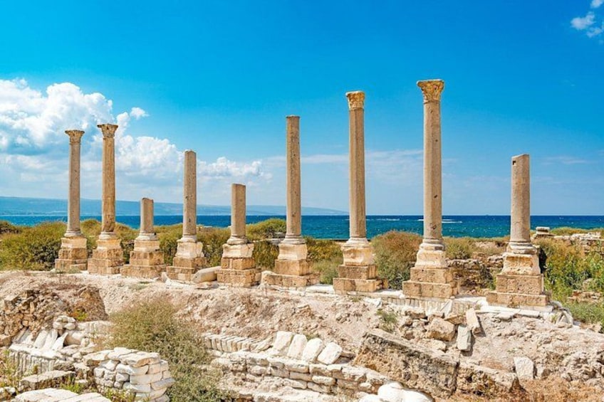 Ancient ruins with columns and stone structures by the sea. 3